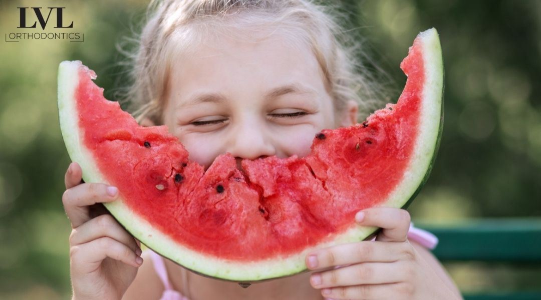 girl eating watermelon and smiling